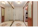 Hallway with tiled floors, mirrored closet doors, and decorative glass-paneled doors to an oven at 7865 E Mississippi Ave # 907, Denver, CO 80247