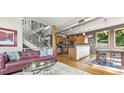 Open living space with hardwood floors, modern staircase, and kitchen access at 396 E Warren Ave, Denver, CO 80210