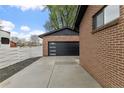 Modern garage with sleek black door and a spacious driveway at 4580 Garland St, Wheat Ridge, CO 80033