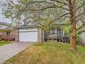 Charming two-story home with a brick-accented garage, porch, and mature tree at 11851 Elm Dr, Thornton, CO 80233