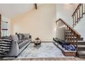 Inviting living room featuring vaulted ceilings, a gray sofa, and stairs leading to a second floor at 9957 Grove Way # F, Westminster, CO 80031