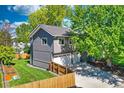 Home exterior with a three-car garage, fenced yard, and mature trees providing shade at 1750 E Noble Pl, Centennial, CO 80121