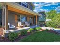 Inviting front porch with cozy seating and wood accents, perfect for relaxing outdoors and enjoying the landscaped yard at 1750 E Noble Pl, Centennial, CO 80121