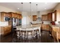 Gourmet kitchen featuring custom wood cabinetry, a central island, and stainless steel appliances at 13507 W 87Th Ter, Arvada, CO 80005