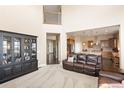 Bright living room featuring soaring ceilings, plush seating, and an open layout with sightlines into the kitchen at 13507 W 87Th Ter, Arvada, CO 80005