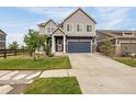Charming two-story home with a well-manicured lawn and a blue garage door at 91 S Quantock St, Aurora, CO 80018