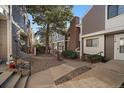 Landscaped walkway featuring charming townhomes, mature trees, and well-maintained exteriors at 6585 W 84Th Way # 120, Arvada, CO 80003