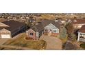 Sprawling home on a large lot with manicured lawns, set against a backdrop of a beautiful neighborhood at 22725 E Long Dr, Aurora, CO 80016