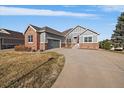 A beautiful house with a long driveway and well-manicured lawn and an attached garage at 22725 E Long Dr, Aurora, CO 80016