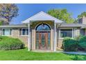 Close-up of the arched wooden front door with sidelights and a covered porch at 3561 Kalispell St, Aurora, CO 80011