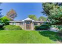 Beautifully landscaped front yard with a brick home featuring a unique arched entryway at 3561 Kalispell St, Aurora, CO 80011