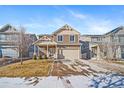 Two-story house with beige and brown siding, attached garage, and landscaping at 5385 Walden Ct, Denver, CO 80249