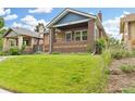 Charming brick home featuring a well-maintained lawn and inviting front porch at 3334 W 37Th Ave, Denver, CO 80211
