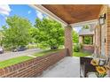 Inviting front porch with brick columns and wood ceiling, perfect for relaxing outdoors at 3334 W 37Th Ave, Denver, CO 80211