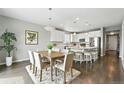 Open-concept kitchen and dining area featuring pendant lighting and a modern design at 12554 Hudson Ct, Thornton, CO 80241