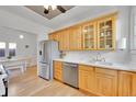 Well-lit kitchen with stainless steel appliances, wood cabinets, marble countertops, and hardwood floors at 1726 N Lafayette St, Denver, CO 80218