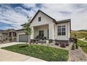 Charming two-story home with a combination of stone and white siding and a well-manicured lawn at 5668 Shadescale Way, Castle Rock, CO 80104