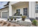 Inviting front porch with seating, potted plants, and a modern front door at 5668 Shadescale Way, Castle Rock, CO 80104