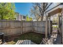 Secluded backyard with a wood fence, a small grass area, and a covered patio area for entertaining at 8745 Yukon St # 30, Arvada, CO 80005