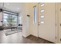 Bright living room with a unique garage door-style window providing ample natural light and stylish, modern decor at 10117 Morrison Rd, Lakewood, CO 80227
