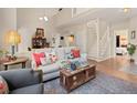 Bright living room with soaring ceilings, hardwood floors, and a view of the stairs at 10105 Grove Loop # D, Westminster, CO 80031