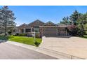 Well-maintained home exterior with a three-car garage, manicured lawn, and mature landscaping at 9561 Silver Hill Cir, Lone Tree, CO 80124