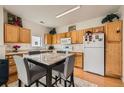 Functional kitchen with light wood cabinets, stainless steel appliances, and an eat-in dining table at 16828 E Gunnison Dr # 7H, Aurora, CO 80017