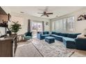 Cozy living room featuring a large blue sectional sofa, a plush rug, and natural light from the sliding patio door at 16828 E Gunnison Dr # 7H, Aurora, CO 80017