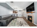 Open living room with fireplace, L-shaped sectional sofa, and kitchen view at 1330 S Monaco Pkwy # 3, Denver, CO 80224