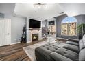 Living room with fireplace, gray sectional sofa, and wood floors at 1330 S Monaco Pkwy # 3, Denver, CO 80224