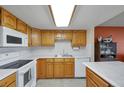 A bright kitchen with wood cabinets, white countertops, and appliances at 14001 E Marina Dr # 607, Aurora, CO 80014