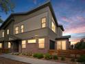 Home exterior at dusk highlighting a blend of brick and siding architecture with well-lit windows at 11719 W 45Th Pl, Wheat Ridge, CO 80033