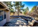 Large outdoor deck area offering ample space for seating and entertaining, surrounded by mature trees and foliage at 36635 View Ridge Dr, Elizabeth, CO 80107