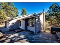 Home exterior featuring a well-maintained deck, siding, and windows, surrounded by mature trees and natural landscaping at 36635 View Ridge Dr, Elizabeth, CO 80107