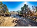 Cozy home with an attached garage and a partially shaded driveway with a supplemental storage shed at 36635 View Ridge Dr, Elizabeth, CO 80107