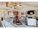 Open-concept living room featuring a fireplace, vaulted ceiling, and kitchen view at 9046 Sandpiper Dr, Frederick, CO 80504