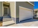 Side view of a new house with white garage door and gray entrance, with a lawn under construction at 4114 Estrella St, Brighton, CO 80601