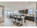 Eat-in kitchen featuring an island with bar seating, stainless appliances, and adjacent dining area at 4114 Estrella St, Brighton, CO 80601