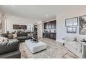 Open-concept living room featuring recessed lighting, a bar area, and views into the kitchen at 4114 Estrella St, Brighton, CO 80601