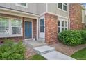 Close-up of the townhouse entrance showcasing the blue front door and brick facade at 9679 W Chatfield Ave # C, Littleton, CO 80128