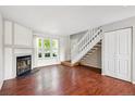 Bright living room featuring hardwood floors, a fireplace, and a staircase at 9679 W Chatfield Ave # C, Littleton, CO 80128
