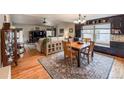 Open concept dining area features hardwood floors, natural light, and a decorative rug at 13642 Wrangler Way, Mead, CO 80542