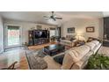 A sun-lit living room features a ceiling fan, hardwood flooring, and access to the backyard at 13642 Wrangler Way, Mead, CO 80542