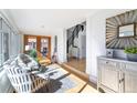 Bright living room with hardwood floors, stylish furniture, and a sunlit view through double doors to a fenced-in yard at 4729 W 32Nd Ave, Denver, CO 80212