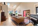 Bright open concept featuring skylights, a grand piano, hardwood floors, comfortable leather sofa, and views at 24045 High Meadow Dr, Golden, CO 80401