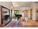 Inviting living room featuring a grand piano, a large mirror, a leather sofa, and beautiful hardwood floors at 24045 High Meadow Dr, Golden, CO 80401