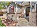 Inviting front entrance with brick accents, decorative plants, and a welcome sign at 7823 E 130Th Pl, Thornton, CO 80602