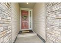 Charming entryway with a traditional wooden door, decorative wreath, and a welcoming stone facade at 3162 Grizzly Peak Dr, Broomfield, CO 80023