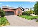 Attractive brick home with an attached two-car garage and mature landscaping at 13983 E 104Th Pl, Commerce City, CO 80022