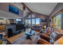 Open living room boasts vaulted ceilings, stone fireplace and stunning views from many windows at 11222 Conifer Mountain Rd, Conifer, CO 80433